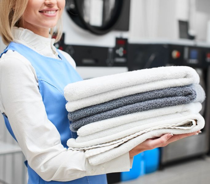 Portrait of a laundry worker on the background of clothes on hangers in dry cleaning Portrait of a laundry worker on the background of clothes on hangers in dry cleaning