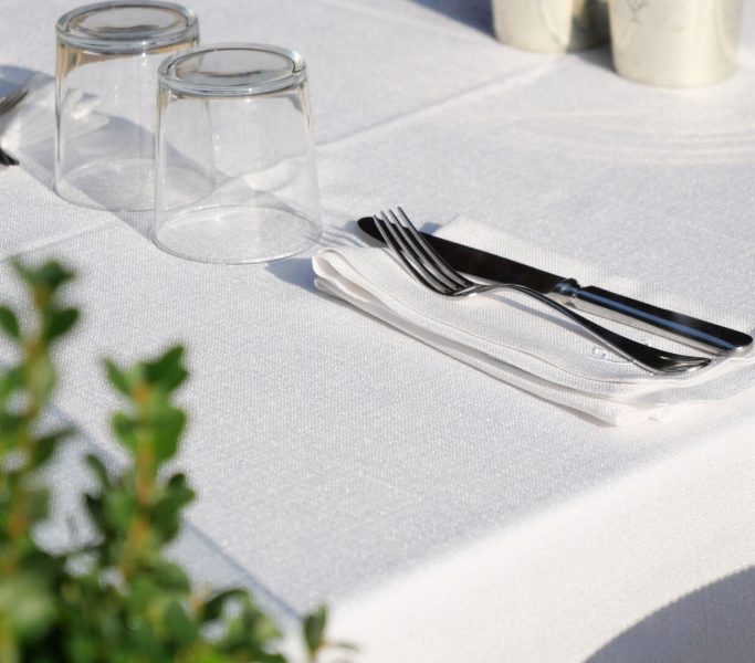 An Elegant Dining Table Setting Featuring Silverware and Beautiful Glasses A beautifully arranged dining table set with elegant utensils, fine glassware, and decor